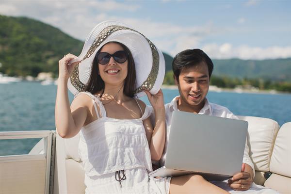 Couple Using Laptop Aboard Yacht